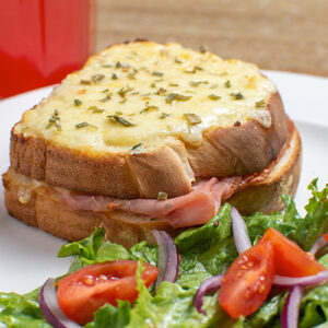 Sandwich con jamón Rovianda, queso gratinado y ensalada.